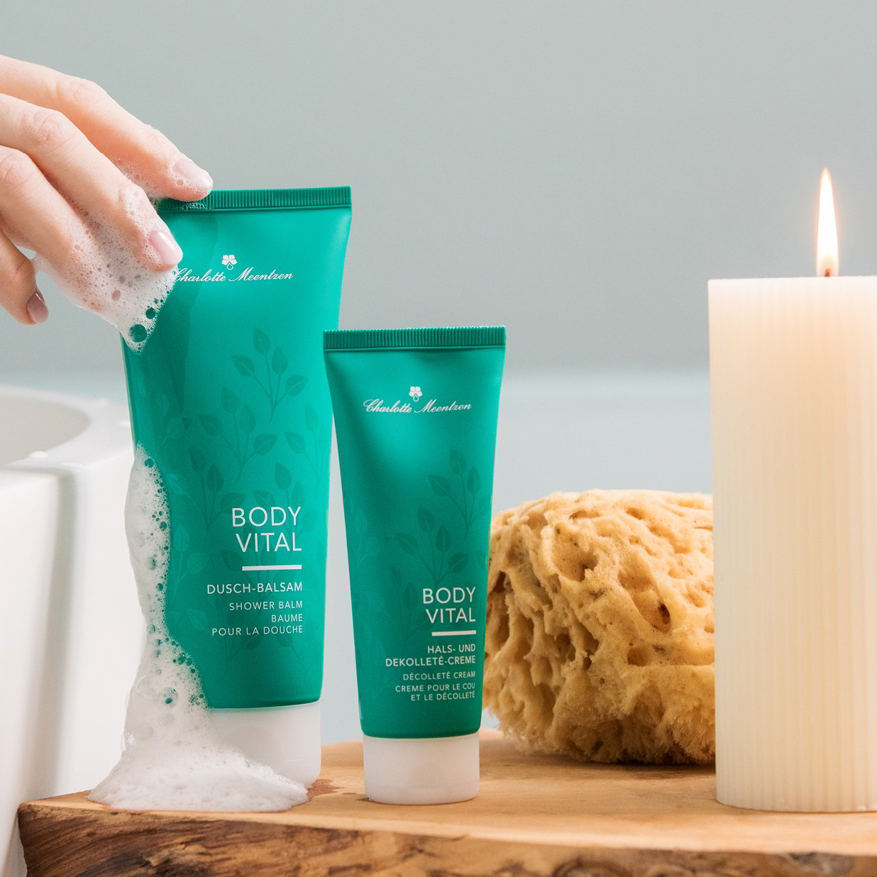 Zwei Body Vital Produkte neben Badewanne und Kerze mit Schaumhand